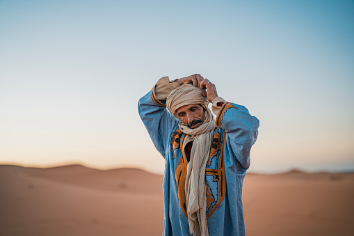 Old Male Tuareg wearing headscarf on North Sahara Desert in Morocco