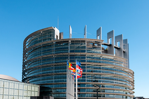 The European Parliament building in Strasbourg, France with flags waving calmly celebrating peace of the Europe. July 12, 2020.