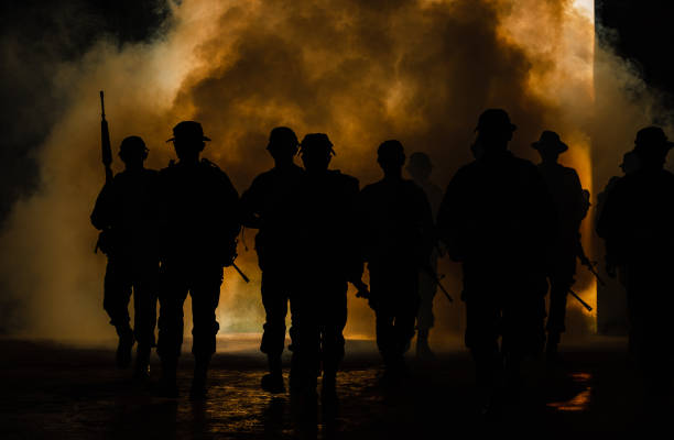 istock silhouette thai soldiers special forces team full uniform walking action through smoke and holding gun on hand 1463925228