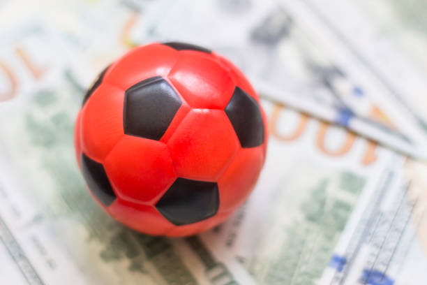 istock Soccer ball on dollars money background 1463937380