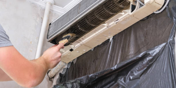 istock man cleans an air conditioner with a brush. Split system maintenance. 1463938730