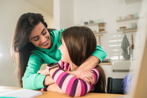 istock Happy woman helping her daughter with homework 1463949581
