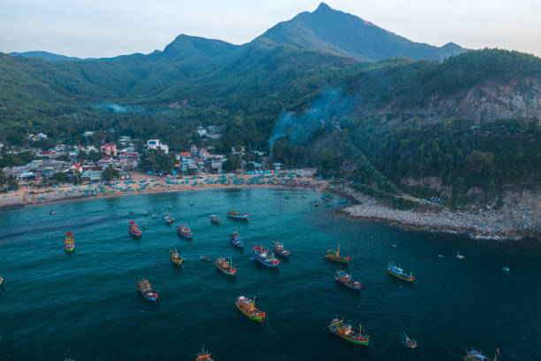 Drone view of a fish market on Xuan Hai beach in early morning with full of fishesh on the basket boat, Song Cau town, Phu Yen province, central Vietnam