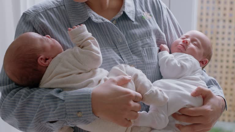 mother holding sleeping babies tired newborns resting with mom gently soothing infants nurturing children enjoying motherhood