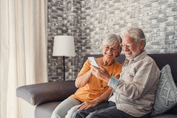 istock Elderly grandfather and grandmother spend time having fun using smartphone apps, middle-aged wife enjoy online entertainments, taking selfie with old husband, older generation and modern tech concept 1463965820
