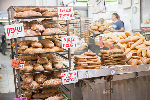 Tel Aviv, Israel - June 17, 2022:  Freshly-baked loaves of bread and bagels for sale at Carmel Market (Shuk Hacarmel), Tel Aviv