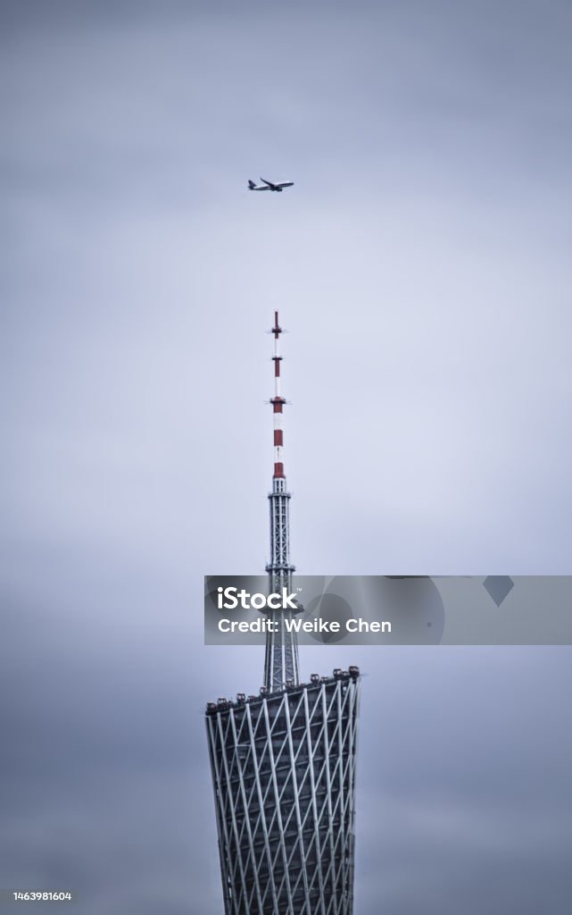 Guangzhou Tower A plane flys over Guangzhou Tower Airplane Stock Photo