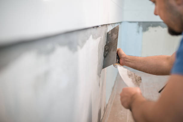 istock Back view of a worker in coveralls affixing kitchen tiles 1463982520