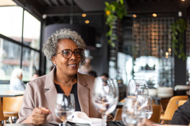 femme d’affaires noire dans un restaurant sophistiqué - restaurant dinner dining gourmet photos et images de collection