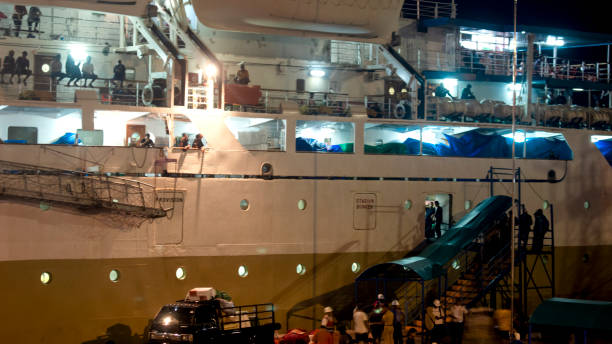 many people were getting on the ship at night to depart - depart imagens e fotografias de stock