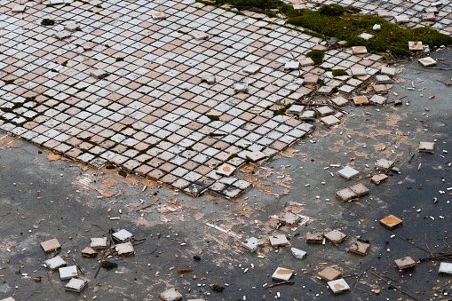 An abstract image of the texture of small broken floor tiles at an abandoned construction site.