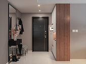 Front Door Entrance To House With Hassock, Cabinets, Coat Hook And Mirror In Corridor