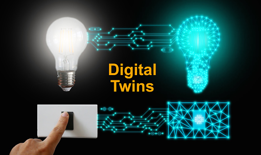 Digital twins concept. A light bulb and its mirrored body are controlled or switched on by one single push on either side of the physical or digital world. Business and technology simulation modeling