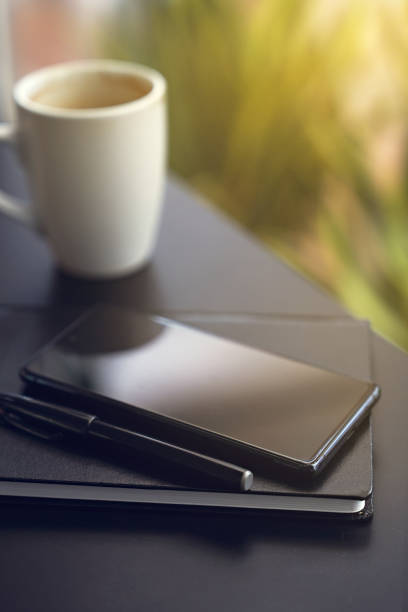 Close up smartphone and note book on black desk stock photo