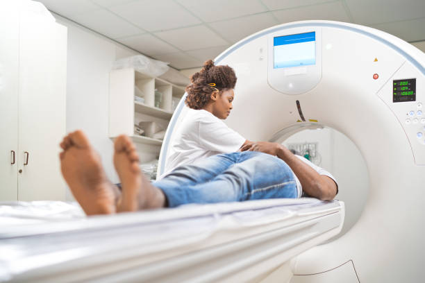 médico asistente al paciente masculino mientras realiza una resonancia magnética en la sala de examen médico - mri scan radiologist cat scan cat scan machine fotografías e imágenes de stock