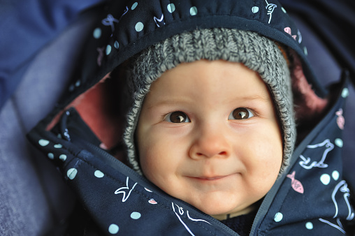 Happy cute smiling baby boy in winter jacket and hat. Joy and happiness concept. Love and family emotion