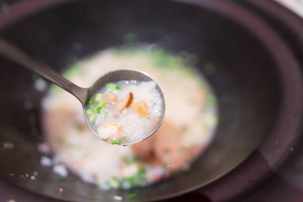 Lady serving seafood porridge with a spoon