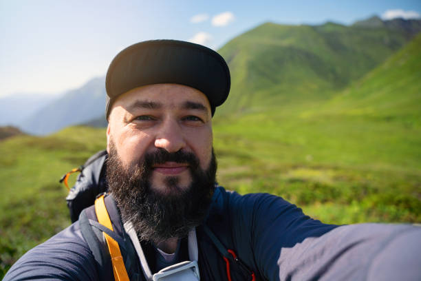 istock Smiling hiker taking selfie high up in the mountains 1464021580