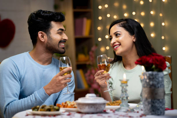 istock Happy smiling couple having wine while talking each other during candle light dinner at home - concept of romantic, dating, relationship and communication 1464025200