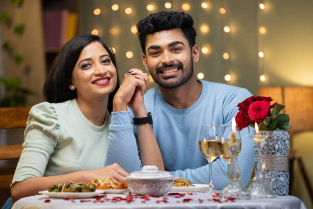 istock Happy smiling couple holding hands by looking at camera during candle light dinner at home - concept of valentine's day, love and relationship. 1464025274