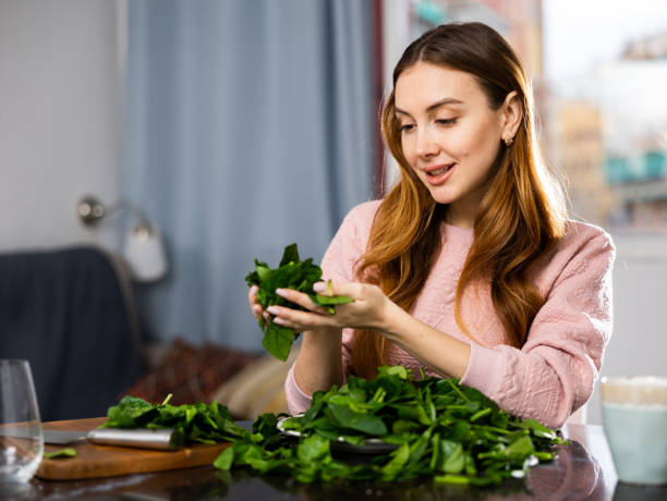 istock Young woman sorts fresh spinach 1464025571