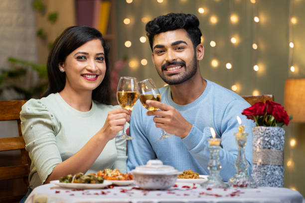 istock Happy smiling couple champagne wine in hands by looking at camera during candle light dinner at home - concept of romantic couple, dating and valentine's day 1464025629