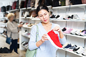 Asian woman chooses red sports slip-ons