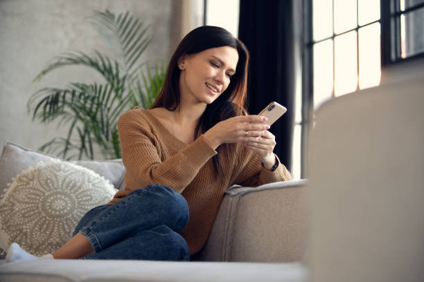 istock Smiling 30s lady chatting in social networks, watching funny videos, using mobile applications at home 1464027828