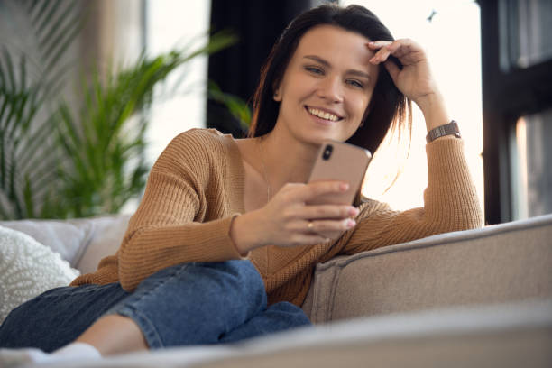 istock Smiling 30s lady chatting in social networks, watching funny videos, using mobile applications at home 1464028006