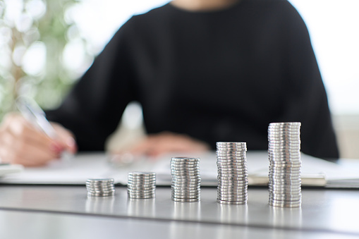 A woman studying investment and a coin stack