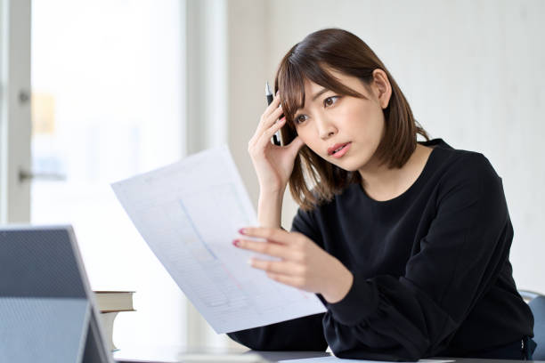 確定申告が心配なアジア人女性 - 書類 ストックフォトと画像