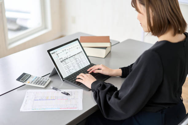 istock Asian woman entering journal entries in accounting software 1464029300