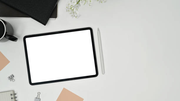 istock Top view of digital tablet with empty screen, cup of coffee and sticky notes on white table. 1464031498