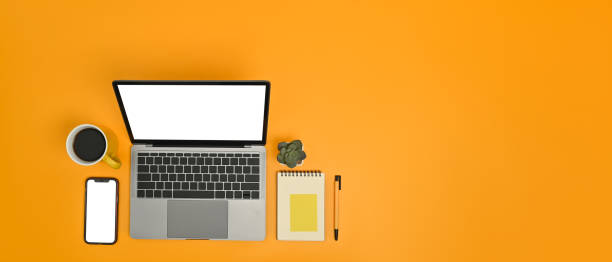 istock Horizontal image of laptop, smart phone notepad and coffee mug on yellow background. Copy space for text information. 1464031550