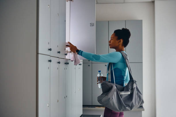 istock African American athlete taking her stuff from a locker after working out in gym. 1464034228