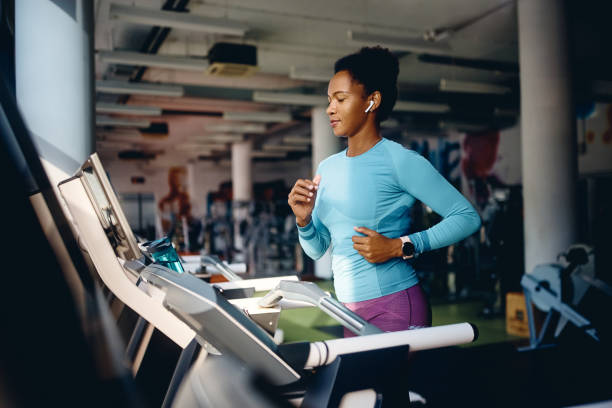 istock Black female athlete running on treadmill while exercising in gym. 1464035332