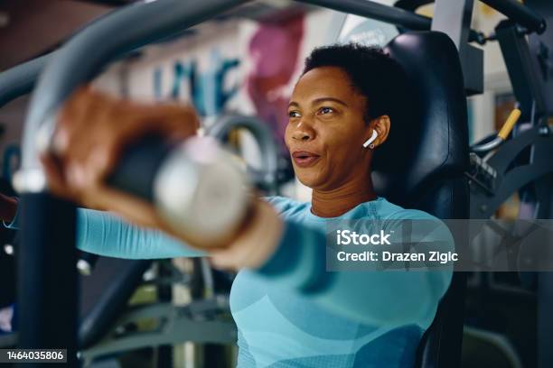 Black Sportswoman Doing Chest Exercises On Machine While Working Out In Gym Stock Photo - Download Image Now