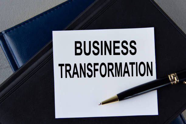 istock Business transformation- words on white sheet on a black leather book with pen 1464043559