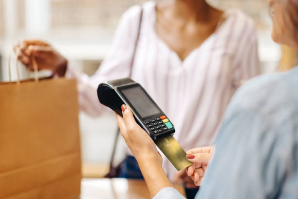 istock Unrecognizable store owner swiping a credit card while serving a customer 1464044331
