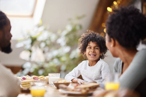 istock Happy black girl and her parents talking during breakfast. 1464044393