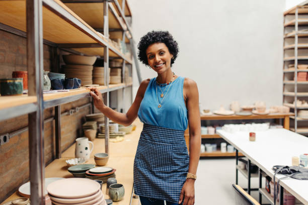 istock Cheerful young ceramist smiling at the camera in her pottery 1464044553