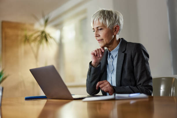 istock Senior entrepreneur reading an e-mail on laptop at home office. 1464047016