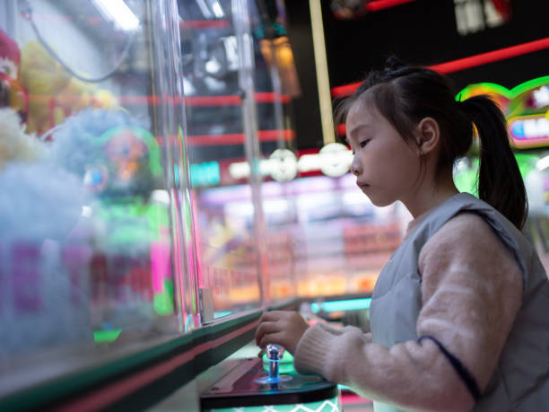 istock little girl playing with claw machine 1464048234