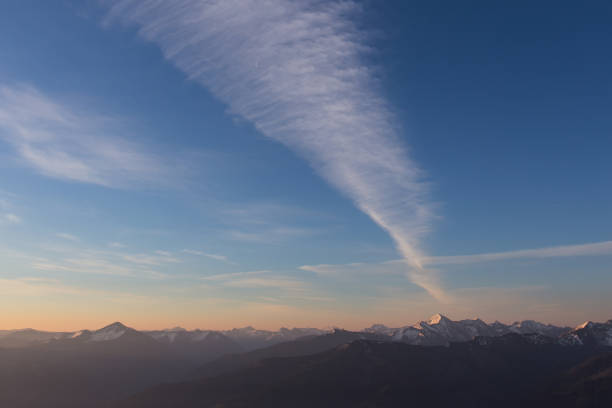 contrail maciço de uma aeronave pela manhã sobre as montanhas - vapor trail night sky sunset - fotografias e filmes do acervo