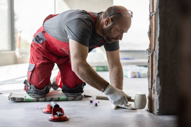 istock Professional tiler fixing newly installed tiles with rubber hammer 1464051041