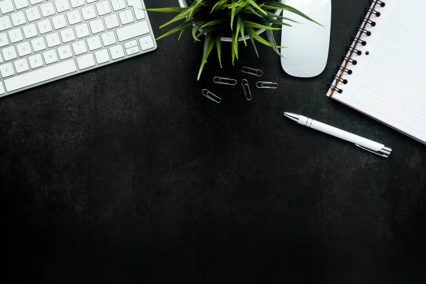 istock Top view of a black working desk with keyboard, plant, notebook and pen - copy space 1464052964