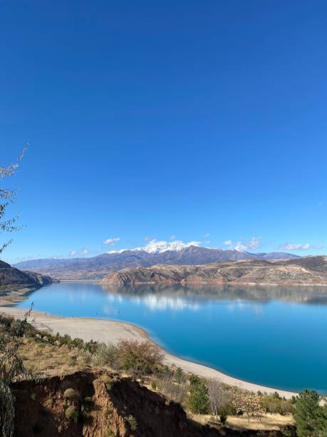 istock Vertical shot of clear blue lake surrounded by hills under blue sky 1464055156