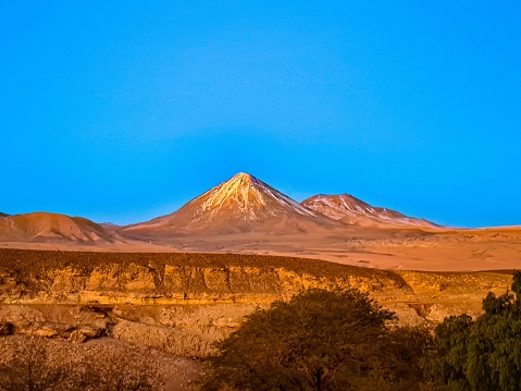 The geological formations in the Atacama Desert before the bright blue background