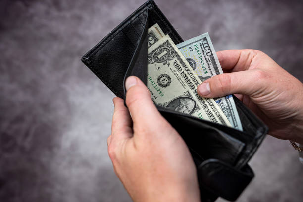 istock Businessman hands holding black leather wallet with dollar bills 1464061640