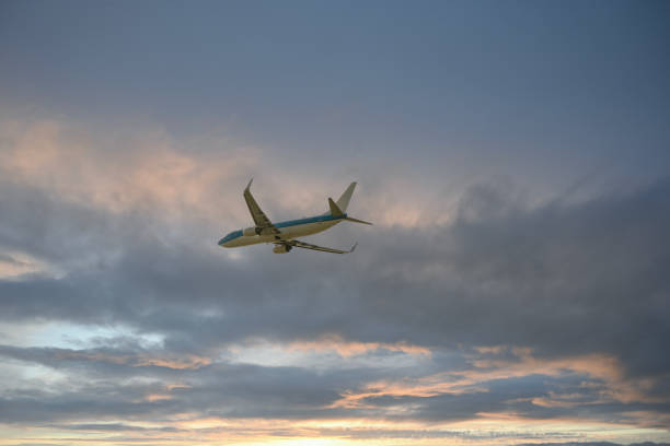 istock Leaving; Airplane in a moody sky at sunrise 1464062307